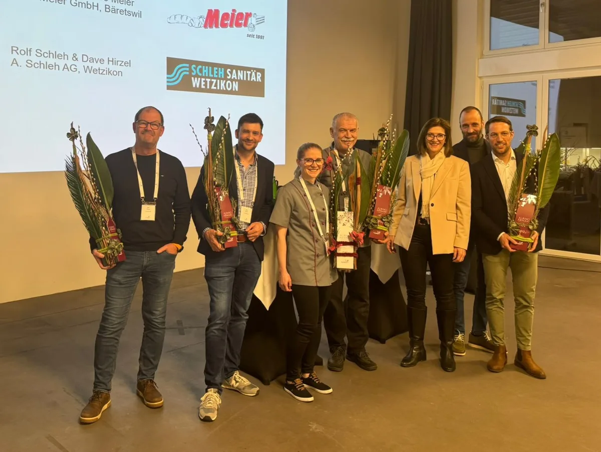 Fünf Männer und zwei Frauen posieren für ein Gruppenbild.